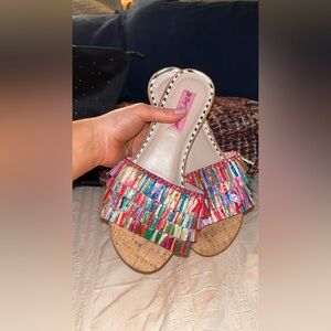 Betsey Johnson’s flat sandals with colorful tassels